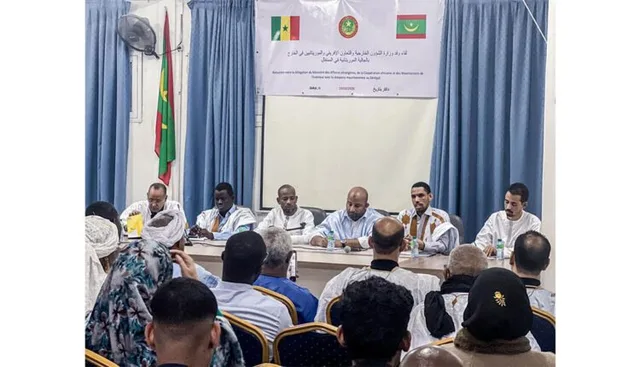 An official delegation on a podium facing members of the Mauritanian diaspora
