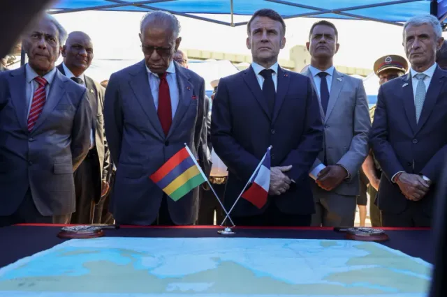 Mauritian and French officials standing at a table with the flags of Mauritius and France and a nautical chart, file photo