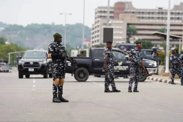 Armed Nigerian police officers on a road in front of a police vehicle, file photo