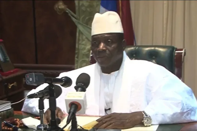 Former Gambian president Yahya Jammeh speaking in front of microphones at his desk