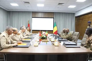 Moroccan and Malian officers around a meeting table in front of both countries' flags