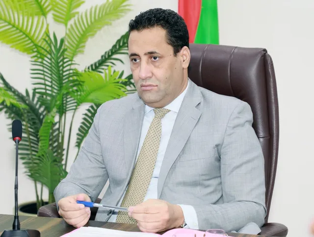 The prime minister seated at a meeting table