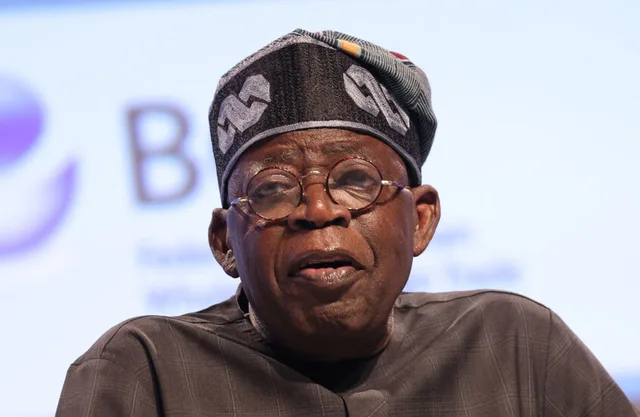 Nigerian President Bola Tinubu, wearing a traditional cap and glasses, speaking at a conference, file photo