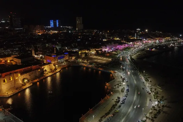Aerial night view of a lit coastal road in Tripoli with cars near the old harbour, file photo