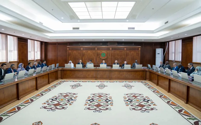 Government members around a large meeting table in an official hall