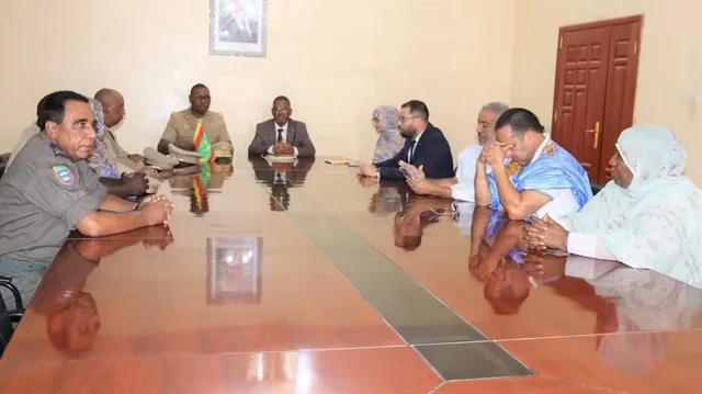 Officials around a meeting table in an administrative office