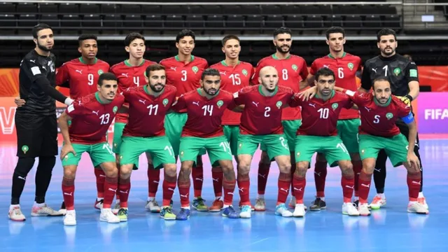 Morocco futsal players in red shirts and green shorts pose for a team photo on an indoor court, file photo