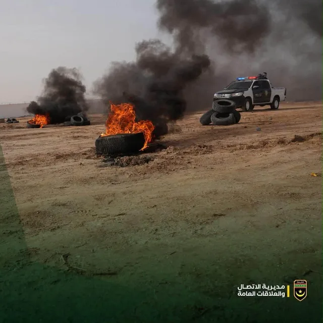 Burning tyres and a police vehicle during a field exercise