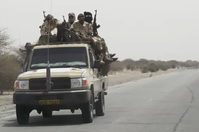 Armed soldiers aboard a pickup on a desert road, file photo