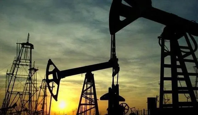 Silhouettes of oil pumpjacks and derricks at sunset, file photo