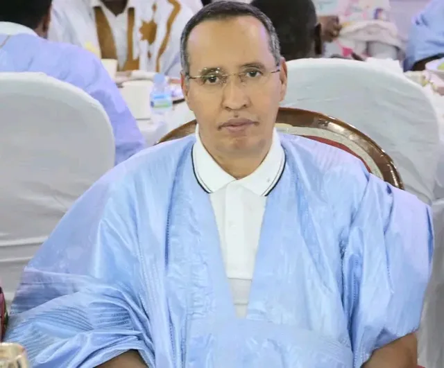 A man in a light blue boubou seated at a reception