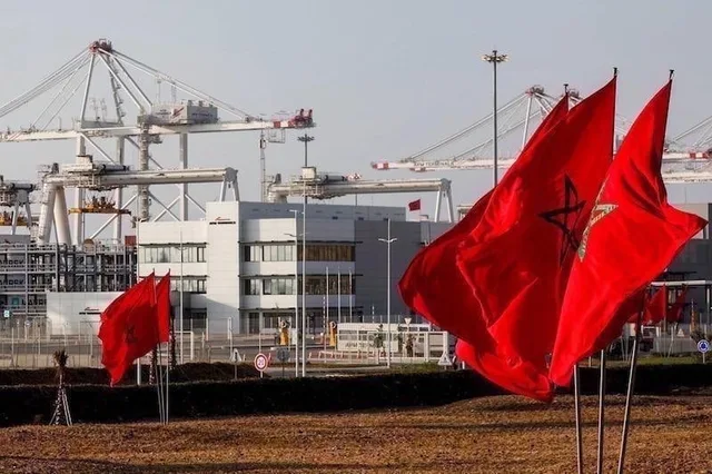 Moroccan flags fly in front of port cranes
