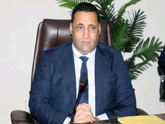 The prime minister seated at a desk with a microphone
