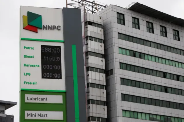 The price board of an NNPC filling station in front of an office building