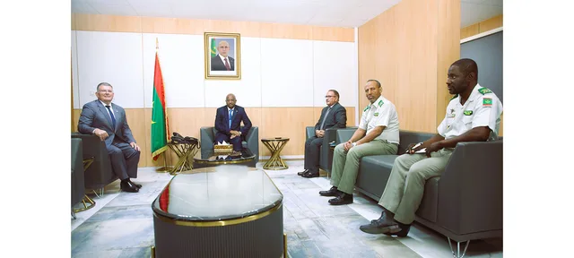 The defence minister and the Czech ambassador meeting with officers in a reception room