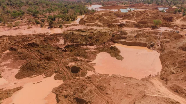 Aerial view of a gold extraction site with pits and muddy pools on red earth, file photo