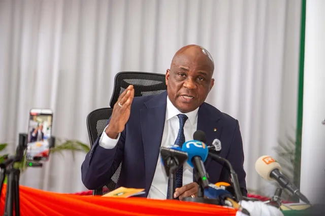 An official speaking in front of microphones at a press briefing