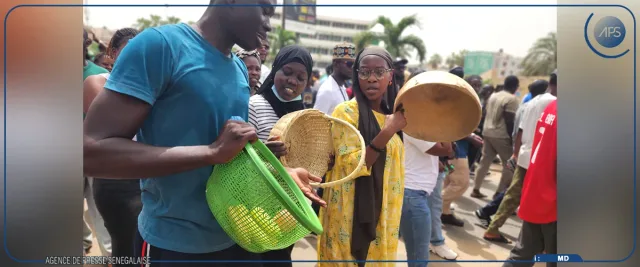Protesters in a Dakar street hold up empty baskets and a calabash during a march against the cost of living, file photo