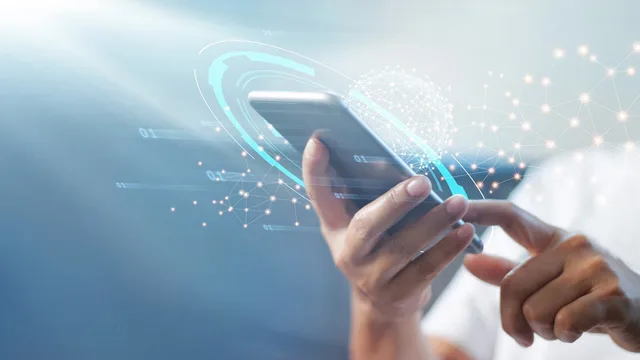 Two hands holding a smartphone surrounded by glowing digital network graphics, illustrative file image