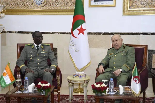 Algeria's army chief of staff seated beside a Nigerien officer in front of both countries' flags