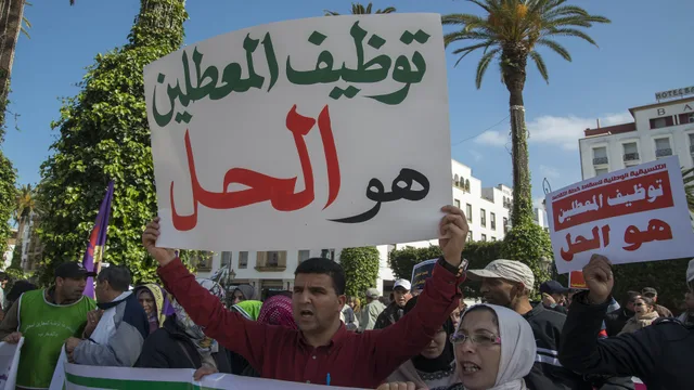 A protester holds up a sign calling for jobs for unemployed graduates during an earlier protest on Mohammed V Avenue in Rabat, file photo