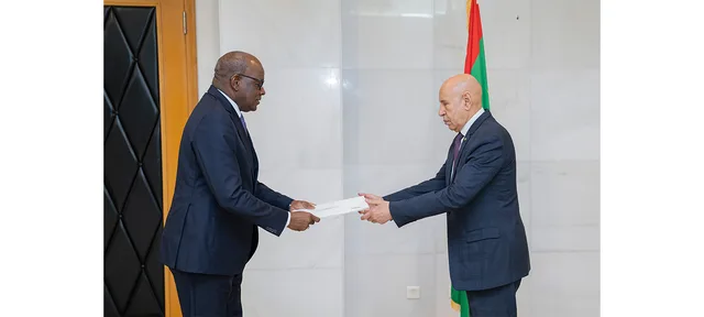 President Ghazouani receives a letter from an ambassador in front of the Mauritanian flag