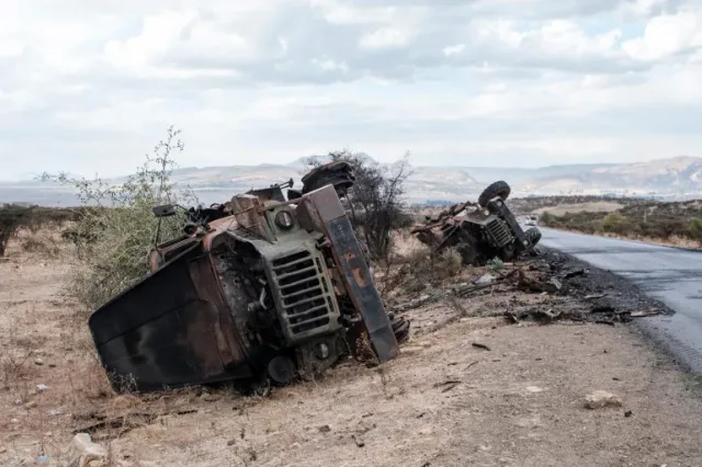 Burnt and overturned military vehicle wrecks by a road in a mountainous area of northern Ethiopia, file photo