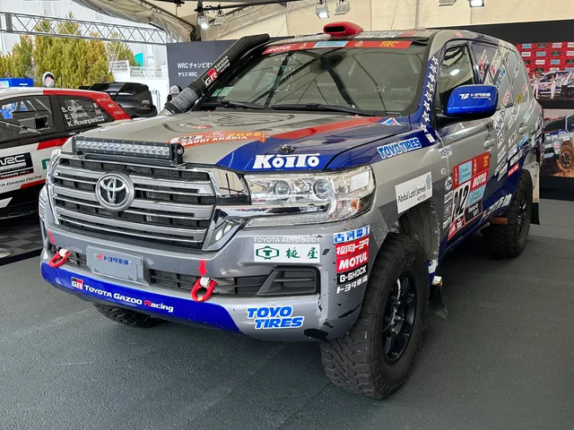 A Toyota Land Cruiser bearing 2022 Dakar Rally stickers on display at an exhibition