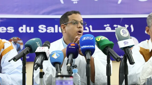 Yacoub Lemrabet speaks into microphones at a Forces of Salvation coalition press conference