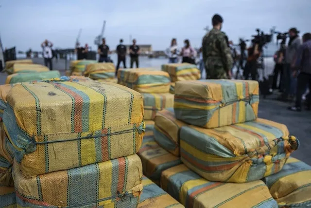 Large bales of seized hashish stacked on a quay in front of reporters, file photo