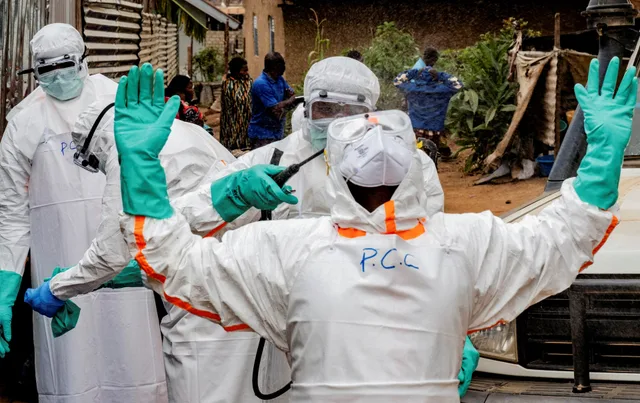 Health workers in full protective suits at an Ebola response site