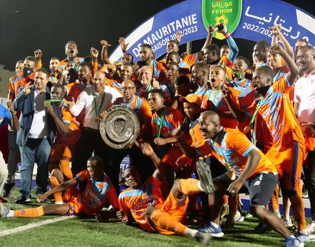 FC Nouadhibou players in orange celebrate with the Mauritanian league shield