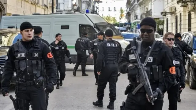 Officers of the Algerian police research and intervention brigade in a street near a police van, file photo