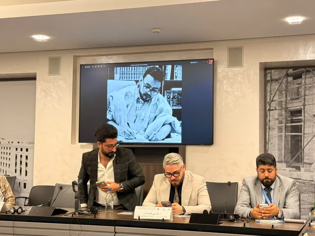 A photo of the late academic projected on a screen during a conference session in Geneva