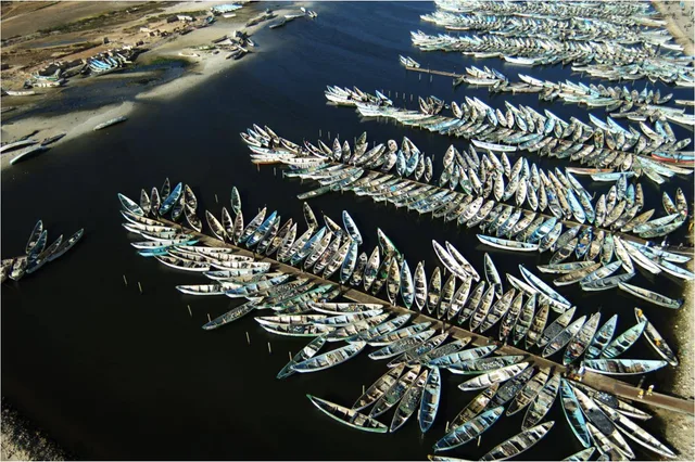 Aerial view of hundreds of artisanal fishing pirogues moored along jetties