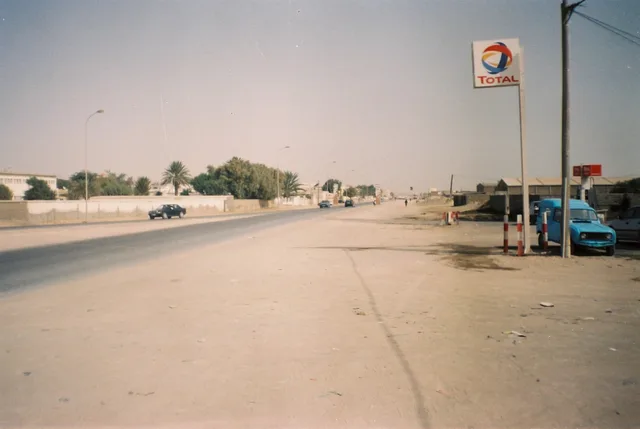 A wide street in Nouadhibou lined with trees and low buildings