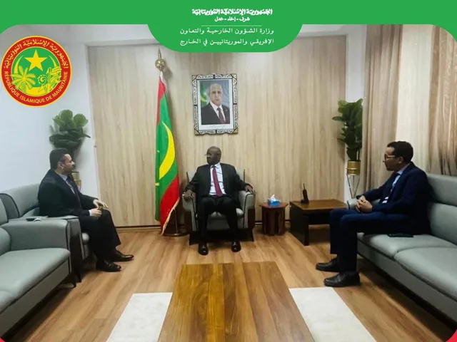 Mauritania's foreign minister receives visitors in his office, with the Mauritanian flag behind him