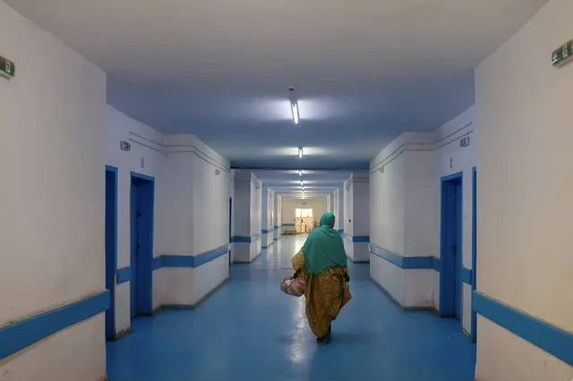 A long hospital corridor with a woman walking