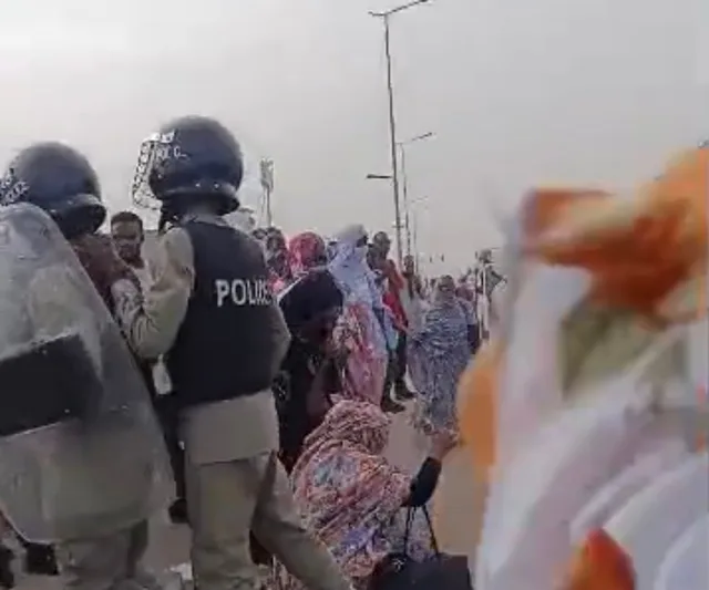 Helmeted police officers facing students gathered on a road in Nouakchott