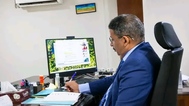 A minister follows a video conference meeting from his office