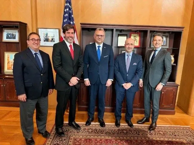 Massad Boulos poses with representatives of ExxonMobil in an office