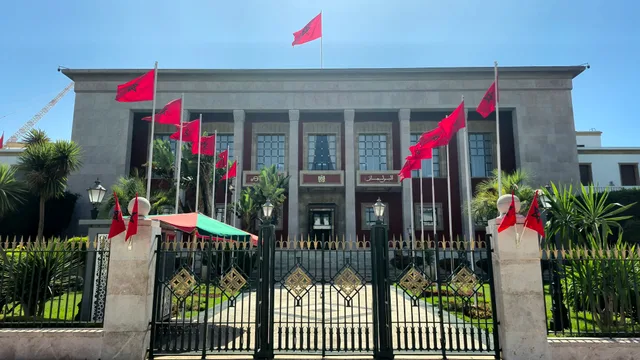 The facade of Morocco's parliament building in Rabat topped with Moroccan flags