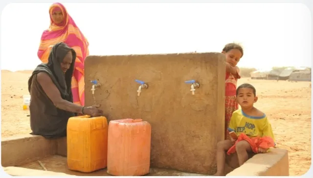 Women and children around a water point with jerrycans