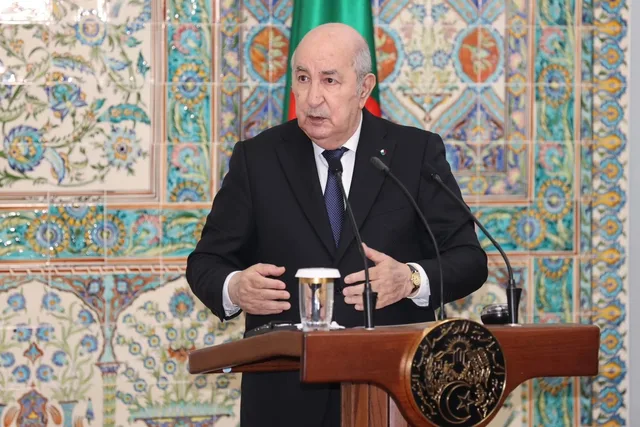Algerian President Abdelmadjid Tebboune speaking at a lectern in front of a tiled wall, file photo