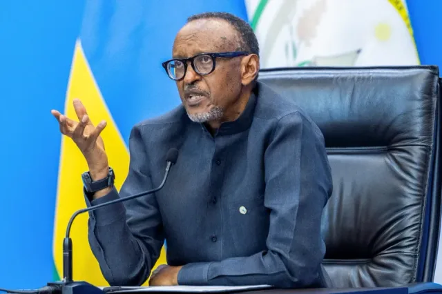 Rwandan President Paul Kagame speaks in front of the Rwandan flag