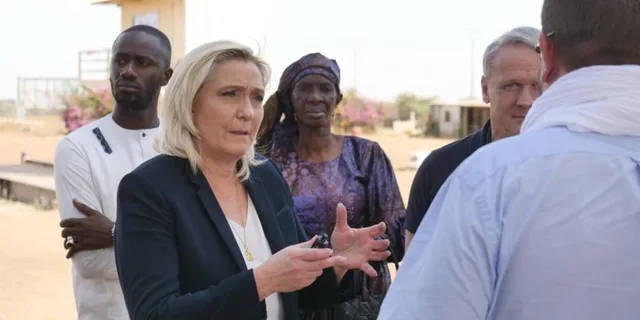 Marine Le Pen speaks outdoors with a group of people, file photo