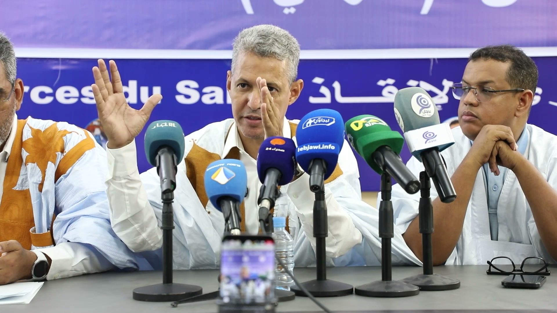 Mohamed Lemine Sidi Maouloud gestures in front of microphones at a Forces of Salvation coalition press conference