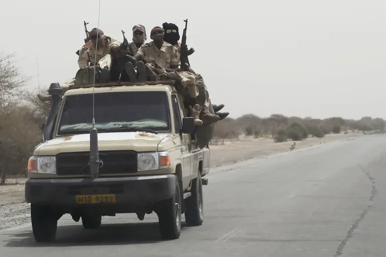 Armed soldiers aboard a pickup on a desert road, file photo