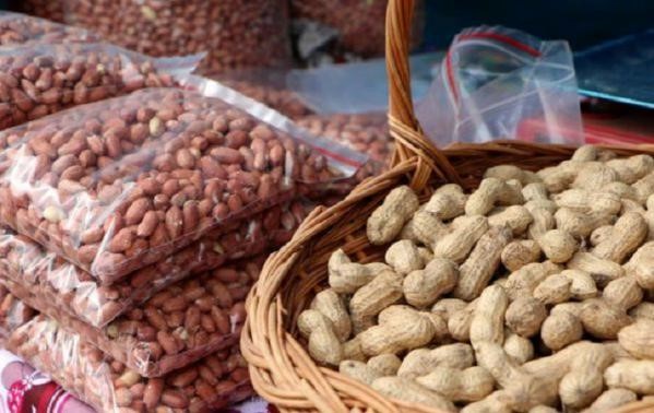 A wicker basket of groundnuts in their shells beside bags of shelled groundnuts, illustrative file photo