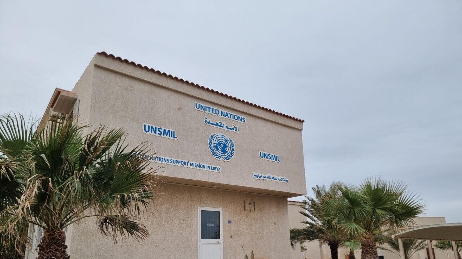Building bearing the United Nations emblem and the name of its support mission in Libya, surrounded by palm trees, file photo
